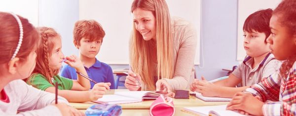 Schüler und junge Frau sitzen am Tisch