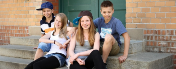 Vier Jugendliche sitzen auf einer Treppe