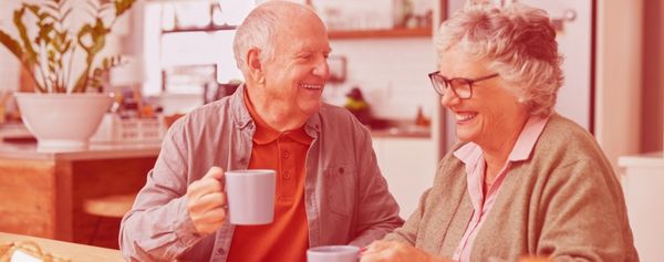 Ein älterer Mann trinkt Kaffee mit einer Dame vom Besuchsdienst