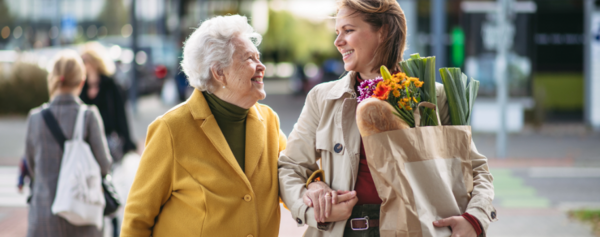 rau geht gemeinsam mit älteren Dame einkaufen