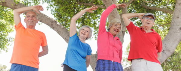 vier Senioren bewegen sich im Freien