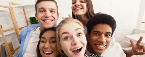 Jugendliche schauen lachend in die Kamera