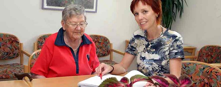 Beratung zwischen Pflegedienstleiterin und älteren Dame